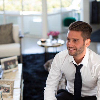 Josh Flagg sitting down with a white button up and black tie
